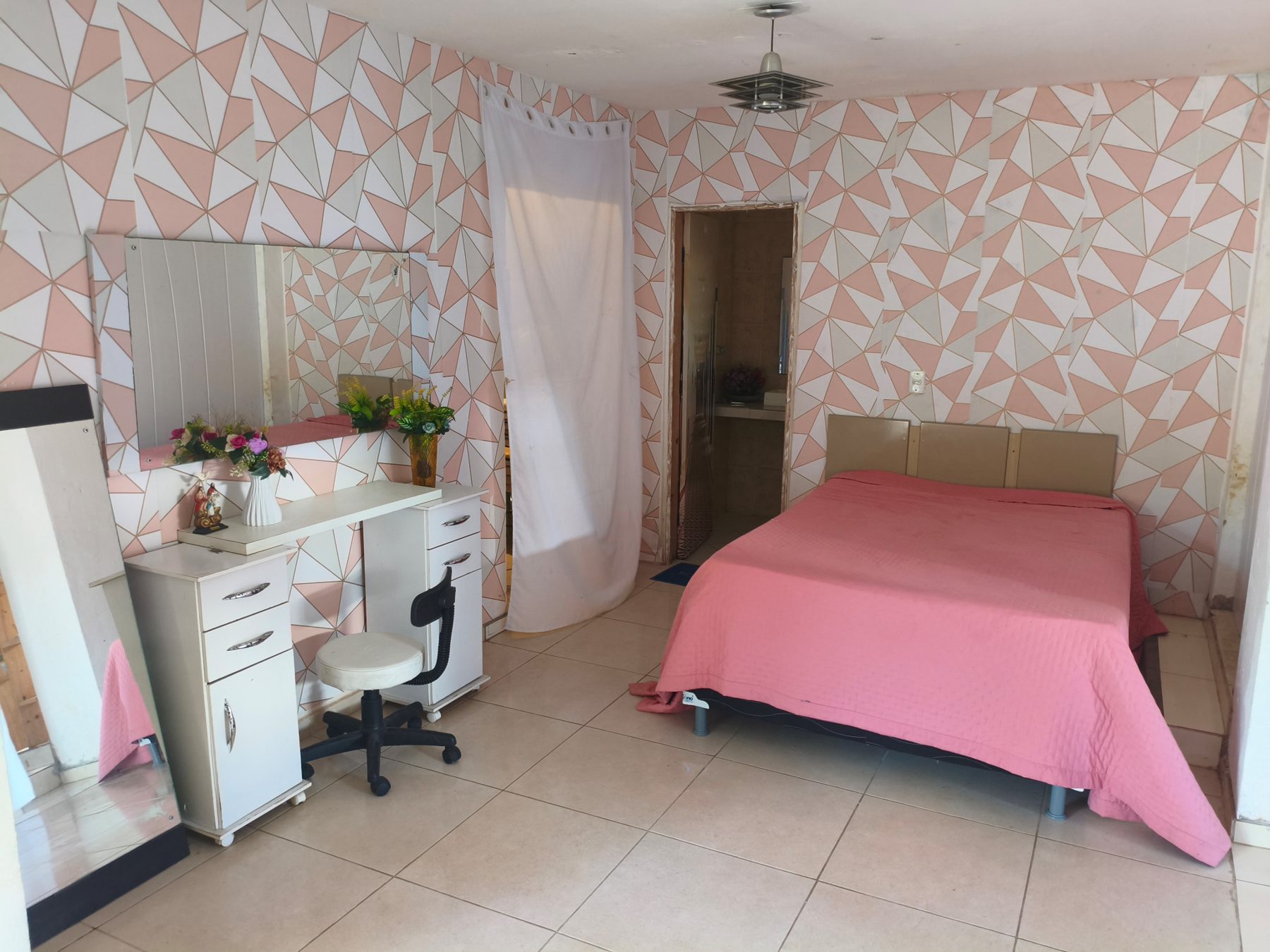 Quarto da noiva do Studio29 com penteadeira, espelho, cama de casal e banheiro privativo