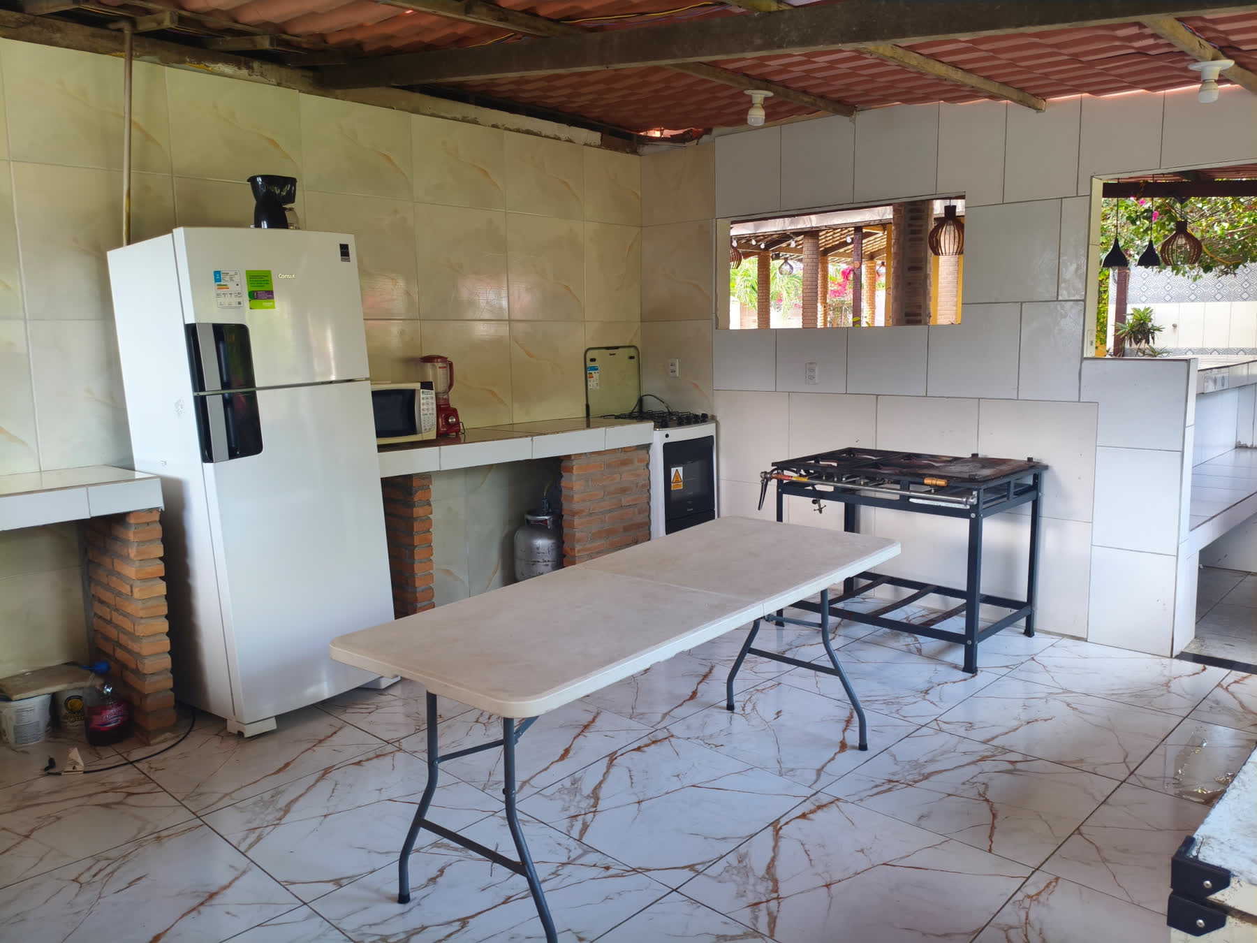 Segunda cozinha do Studio29 com geladeira, fogão, micro-ondas e bancadas