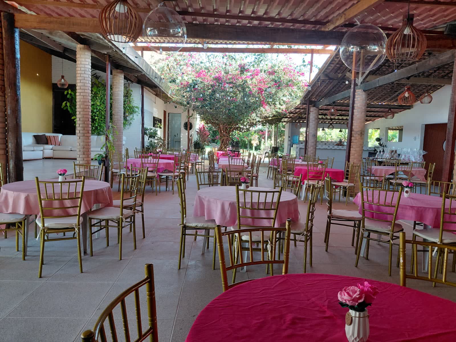 Salão do Studio29 montado com toalhas rosas e cadeiras douradas para festa